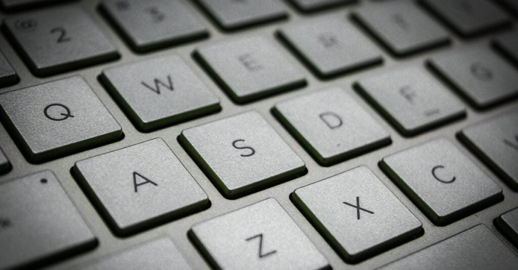 A detailed macro shot of a sleek modern computer keyboard featuring the QWERTY layout.
